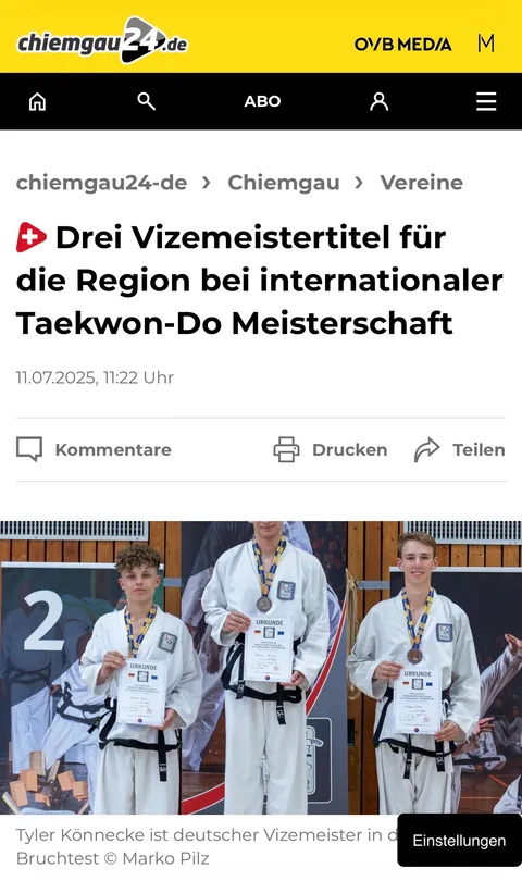Screenshot chiemgau24.de vom 11. Juli 2025: „Drei Vizemeistertitel für die Region bei internationaler Taekwon-Do Meisterschaft" mit Siegerehrung – Tyler Könnecke mit Silbermedaille und Urkunde auf dem Podest