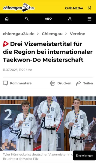 Screenshot chiemgau24.de vom 11. Juli 2025: „Drei Vizemeistertitel für die Region bei internationaler Taekwon-Do Meisterschaft" mit Siegerehrung – Tyler Könnecke mit Silbermedaille und Urkunde auf dem Podest