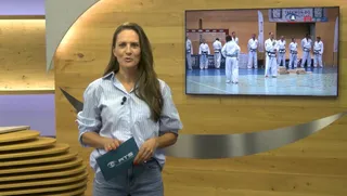 Screenshot RTS Salzburg Magazin vom 21. Juli 2026: Moderatorin im Studio, auf dem Monitor Großmeister in weißen Doboks vor dem Banner des Traditional Taekwon-Do Centers e.V. im Sportzentrum Nord