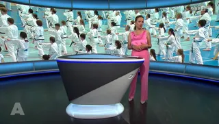 Screenshot ORF 2 vom 13. Juli 2026: Moderatorin im Studio, auf der Studiowand hunderte Taekwon-Do-Aktive aller Gürtelfarben beim gemeinsamen Training im Sportzentrum Nord Salzburg