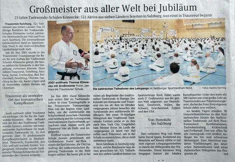 Zeitungsartikel Juli 2026 „Großmeister aus aller Welt bei Jubiläum": Thomas Könnecke im ORF-Interview und die volle Halle im Salzburger Sportzentrum Nord mit hunderten Teilnehmern in weißen Doboks