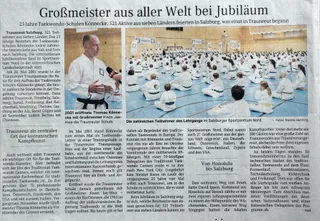 Zeitungsartikel Juli 2026 „Großmeister aus aller Welt bei Jubiläum": Thomas Könnecke im ORF-Interview und die volle Halle im Salzburger Sportzentrum Nord mit hunderten Teilnehmern in weißen Doboks