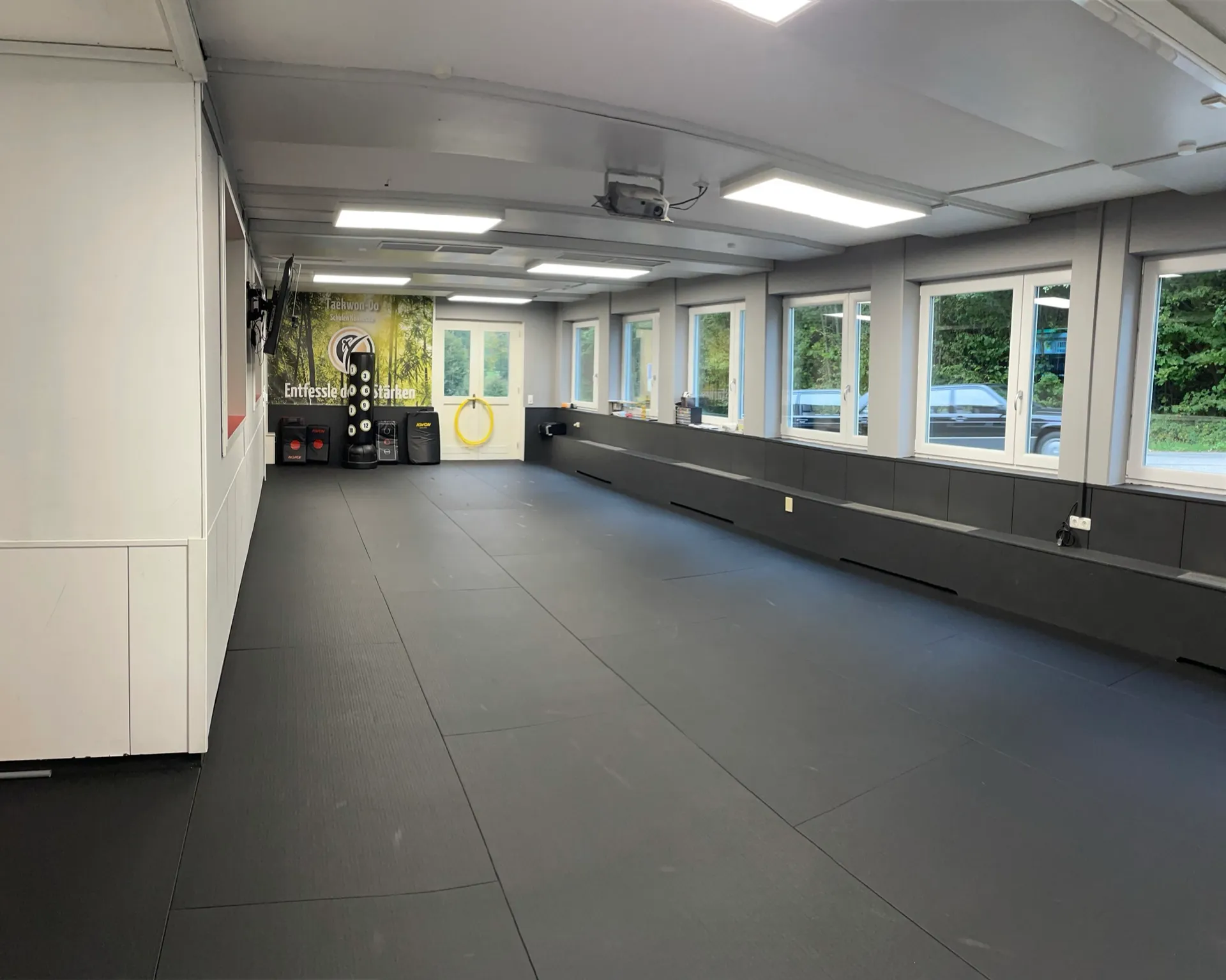 Trainingsraum der Taekwon-Do Schule im Surtal bei Traunstein mit Mattenfläche, Schlagpolstern und großer Fensterfront