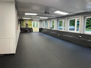 Trainingsraum der Taekwon-Do Schule im Surtal bei Traunstein mit Mattenfläche, Schlagpolstern und großer Fensterfront