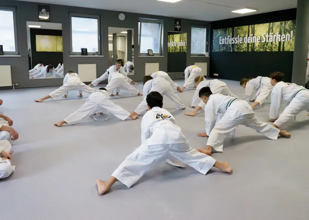 Jugendliche beim Taekwon-Do-Training in Übersee – Dehnübung der Trainingsgruppe