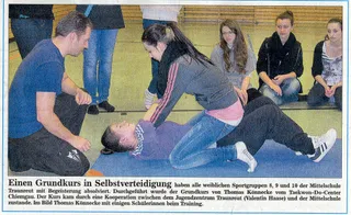 Zeitungsausschnitt "Einen Grundkurs in Selbstverteidigung …" mit Foto von Thomas Könnecke, der einer Schülerin am Boden eine Befreiungstechnik zeigt, umgeben von weiteren Schülerinnen