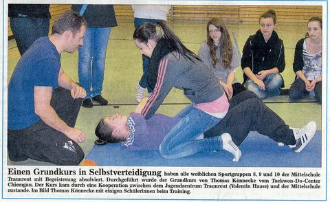Zeitungsausschnitt "Einen Grundkurs in Selbstverteidigung …" mit Foto von Thomas Könnecke, der einer Schülerin am Boden eine Befreiungstechnik zeigt, umgeben von weiteren Schülerinnen