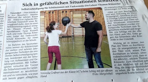 Zeitungsausschnitt "Sich in gefährlichen Situationen schützen" mit Foto von Thomas Könnecke, der einer Schülerin einen Schlag mit der offenen Hand gegen ein Schlagpolster zeigt