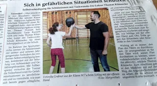 Zeitungsausschnitt "Sich in gefährlichen Situationen schützen" mit Foto von Thomas Könnecke, der einer Schülerin einen Schlag mit der offenen Hand gegen ein Schlagpolster zeigt