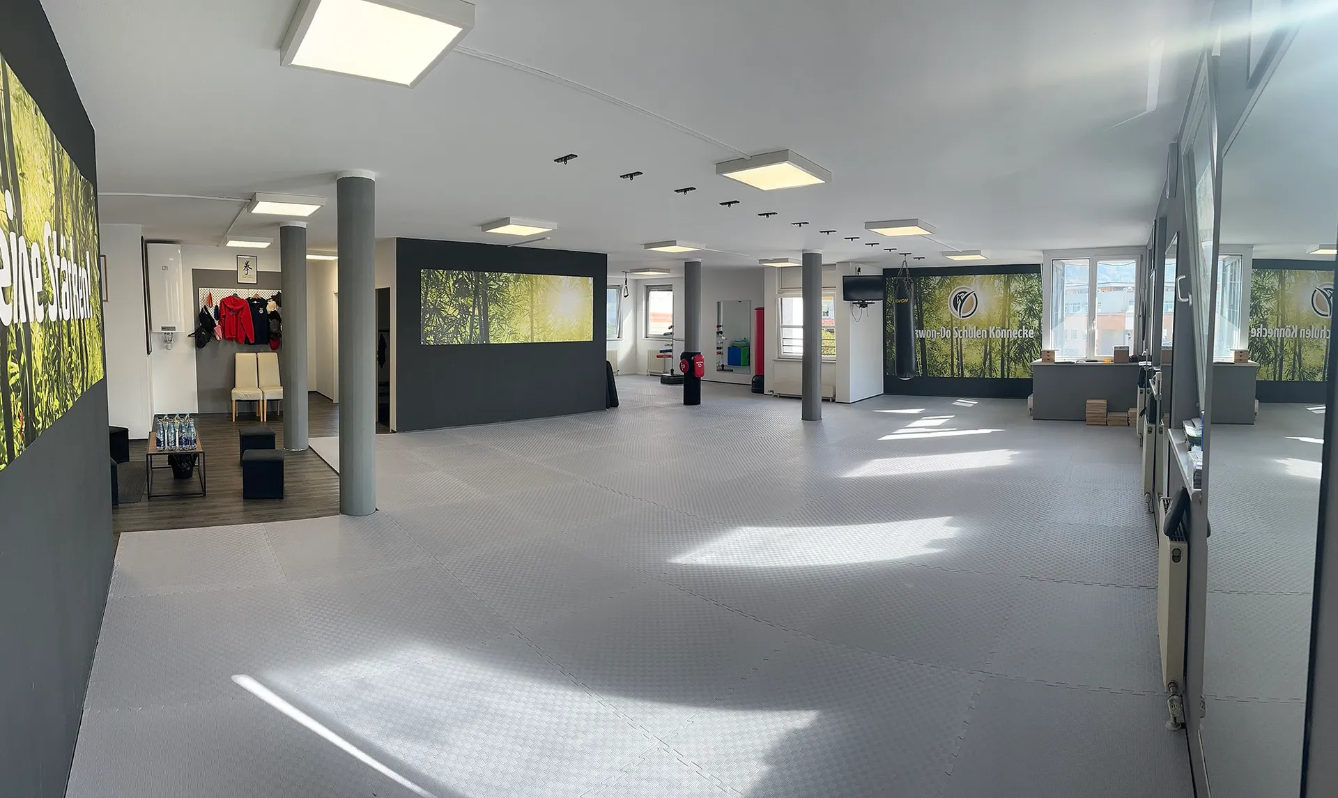 Trainingshalle der Taekwon-Do Schule Könnecke in Salzburg mit Kampfsportmatten, Spiegelwand und Boxsack