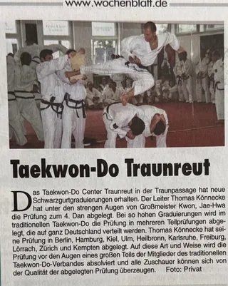 Taekwon-Do-Vorführung in Traunreut mit mehreren Sportlern in weißen Doboks; ein Sportler springt über zwei nach vorn gebeugte Teilnehmer.
