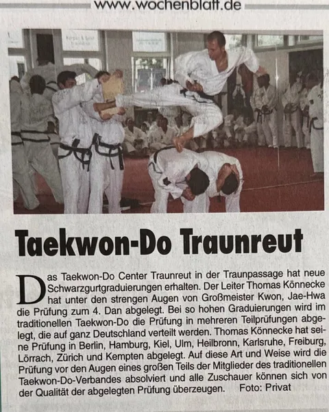 Taekwon-Do-Vorführung in Traunreut mit mehreren Sportlern in weißen Doboks; ein Sportler springt über zwei nach vorn gebeugte Teilnehmer.